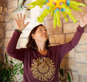 a woman holding a balloon - shaped like a sunflower