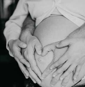 Mains en cœur sur ventre rond – photo de grossesse à domicile dans le Gard