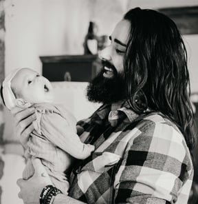 homas, photographe naissance dans le Gard, tenant sa fille dans les bras alors qu’elle baille