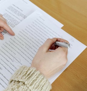 Hand holding a pen writing on paper