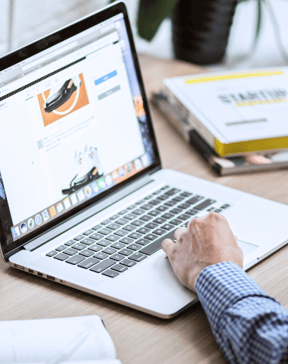 Image of a man at a desk with a laptop open to a website to symbolize website translation and localization services.