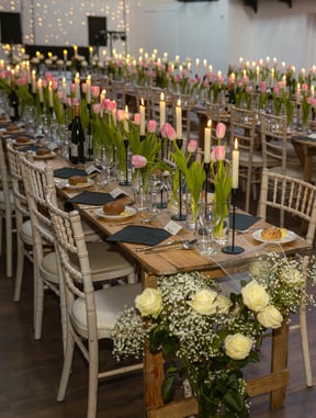 a long table with candles and flowers in a room