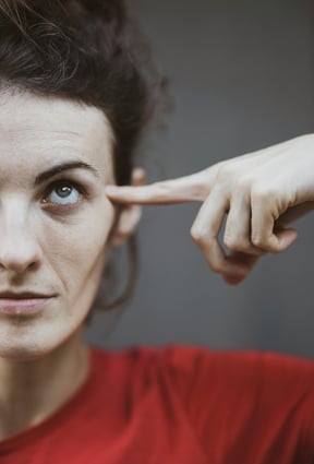 woman pointing to her head