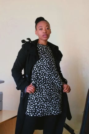 a woman in a black coat and white shirt