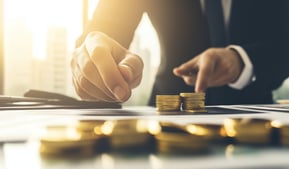 investment manager with gold coins and investing papers