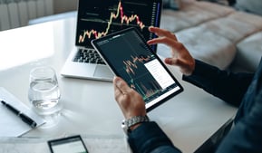 person with interactive investing chart and a calculator