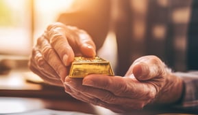 retiree holding gold bar in hands