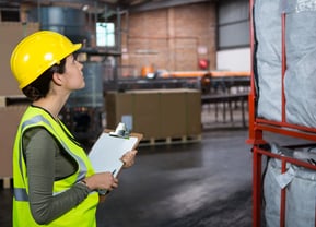a woman in a yellow safety vest and a clipboard