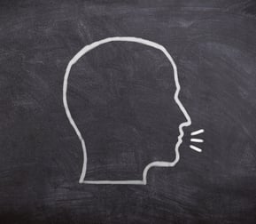 a chalkboard with the drawing of a head in profile talking