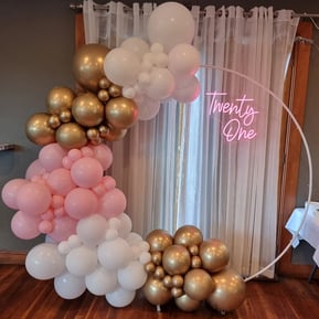 White hoop backdrop with a pink, white and gold garland at Rosa's 21st in Cleveland.