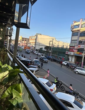 a view of a city street with cars parked on the side of the street