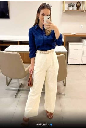 a woman in a blue shirt and white pants