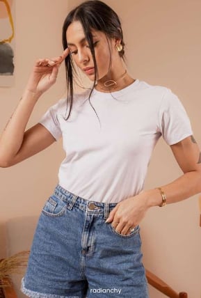 a woman in a white shirt and jeans shorts