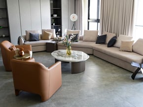 Contemporary living room with neutral tones, curved chairs, and mixed textures. A calm space layered with personality.