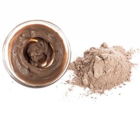 a jar of chocolate pudding with a spoon and a spoon