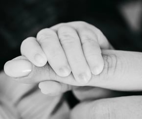 Main de bébé serrant le doigt de sa maman – photo de naissance en noir et blanc dans le Gard