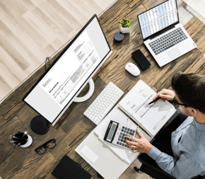 a man sitting at a desk with a calculator to do bookkeeping services and payroll