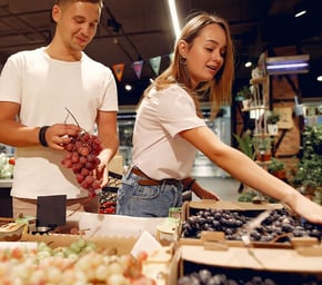 Casal de Homem e Mulher fazendo compras de frutas em um mercado