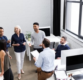 a group of people standing around a desk