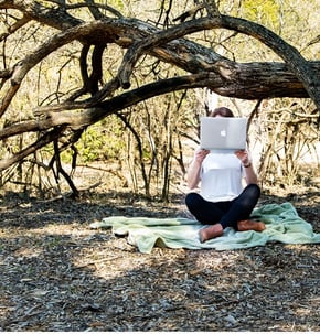 girl in woods with laptop