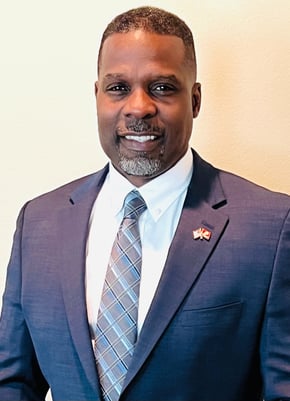 Dr. Marlon Ware professional headshot in blue suit with blue striped tie