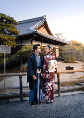 couple dressed in traditional kimonos in kyoto in front of shrine