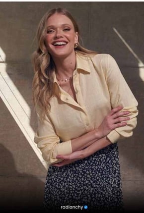 a woman in a yellow shirt and black skirt