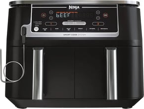 a black and silver air fryer with a knife and a knife in front of