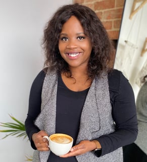 a plus size black woman nutritionist holding a cup of coffee in a room