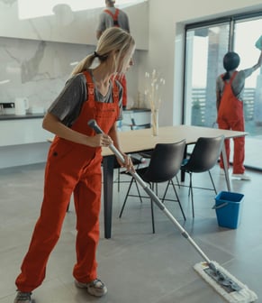 a woman in overalls and overalls cleaning a floor