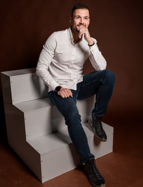 a man sitting on a steplad with his hand on his chin