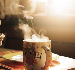 a cup of coffee and a basket of bread