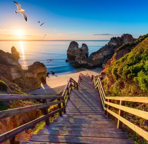 a wooden staircase leading to a beach