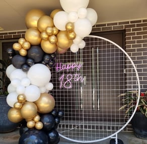 White mesh circle backdrop hired with a black white and gold balloon garland setup for 18th Birthday in Logan.