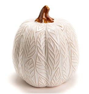 a white ceramic pumpkin with a leafy pattern