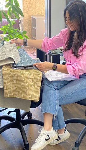 Sigal, founder of Solo Home Decor, selects fabrics while designing custom furniture.