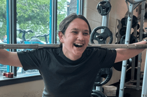 jessica kimball holding a squat bar and smiling