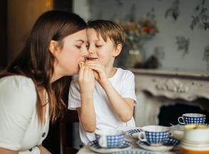 child with autism eating with his mom