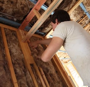 Stuffing an Odenton house frame with insulation