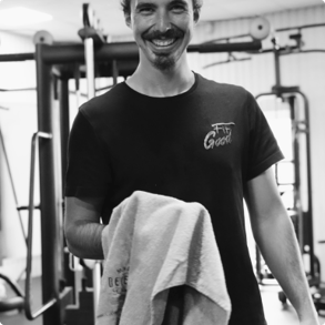 a man in a black shirt is holding a towel in the gym
