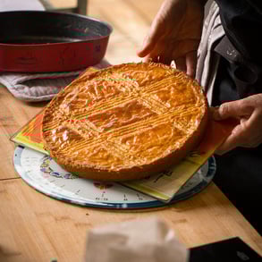 a person holding a cake with a pie