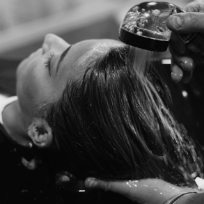 a woman is getting her hair done by a hairdresser