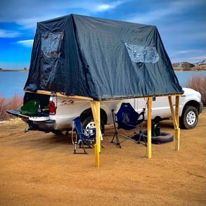 A truck with a fold-out overlanding tent on it's bed