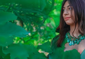 Ritratto immerso nel verde con collana artigianale fotografata da Gaudife – storytelling visivo per gioielli a Bologna