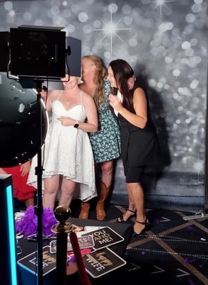 Jucinta and friends standing in the digital open air photo booth with the silver glitter backdrop at her engagement party in 