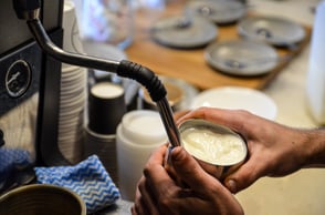 Milk frothing for a coffee order in Melbourne