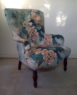 Modern armchair with new upholstery and blue velvet fabric, printed with a tropical bird and flower design