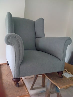 Antique armchair with new upholstery and pale blue fabric