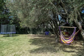 Le jardin de l'Enclos du Soleil le Vent dispose de hamacs et trampoline pour se relaxer et s'amuser
