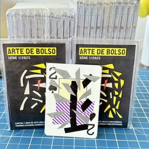 carta dois de espadas na frente de diversos pacotes fechados da série arte de bolso.